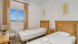 twee bedden in een kamer met een raam bij Seaview apt with pool by Costarentals - Ref 188 in La Cala de Mijas +17 foto's
