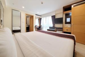 سيتن براتونام بانكوك باي كومباس هوسبيتاليتي في بانكوك: غرفة نوم مع سرير أبيض كبير في غرفة