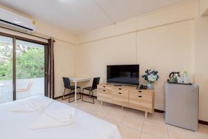 a bedroom with a bed and a television and a table at Hillside Resort in Pattaya Central