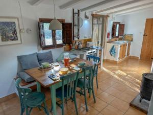 a kitchen and dining room with a wooden table and chairs at Wonderful comfortable finca in the Burga valley in Rasquera