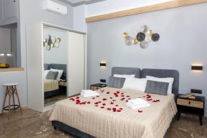 una camera da letto con un letto con rose rosse di Queen Mary Beachfront Studios a Chania