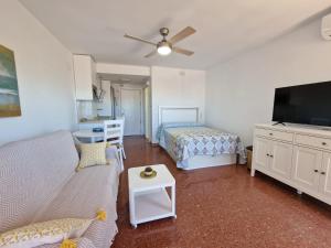 a living room with two beds and a flat screen tv at Apartamento SEREVA Plazamar in Torre del Mar