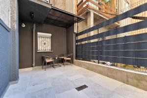 un patio avec des chaises et une table dans un bâtiment dans l'établissement Nest Apartments Sarajevo, à Sarajevo