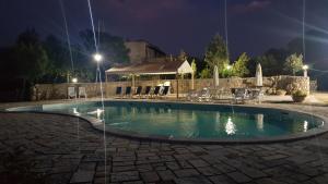 a swimming pool in a yard at night at Agriturismo PETRA LUCANA in Montescaglioso
