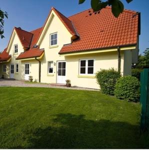 a white house with a red roof at Sybille Sonnenbrille in Wulfen auf Fehmarn