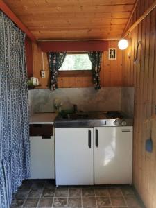 uma cozinha com armários brancos, um lavatório e uma janela em Løken Camping - trivelig og idyllisk ved vannet em Olden