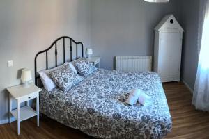Schlafzimmer mit einem Bett mit blauer und weißer Bettwäsche und Kissen in der Unterkunft El Balcó del Bastareny Apartamento renovado 6p in Guardiola de Berga