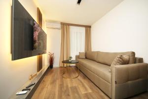 a living room with a couch and a tv at Nest Apartments Sarajevo in Sarajevo