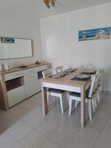una sala da pranzo con tavolo, sedie e lavagna di Apartamento Orla-Mar a Vila Nova de Cacela