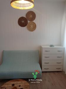 a bedroom with a green couch and a dresser at Il Fico d'India in Leporano Marina