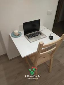 a laptop computer sitting on top of a white desk at Il Fico d'India in Leporano Marina