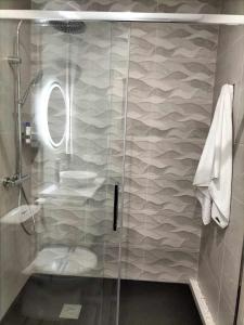 y baño con ducha y puerta de cristal. en Apartamento Turístico Almagre, en Almagro