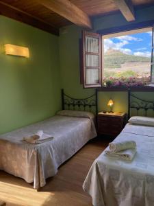 a green room with two beds and a window at El manzano in Castrojeriz