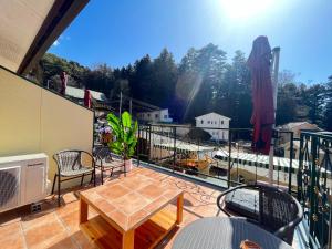 balcón con mesa, sillas y vistas en La Posada, en Fujikawaguchiko