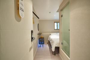 Cette petite chambre dispose d'un lit et d'un couloir. dans l'établissement Life in Euljiro, à Séoul
