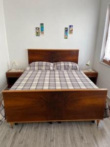1 cama de madera en un dormitorio con 2 mesitas de noche en CASA CELSA, en Mongiove