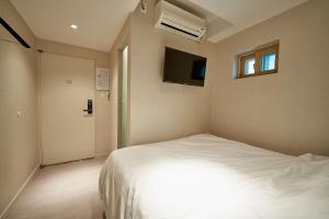 a bedroom with a white bed and a tv at Life in Euljiro in Seoul