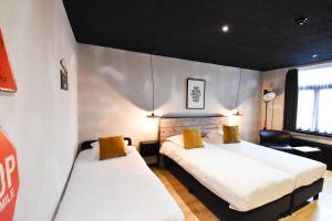 een kamer met 2 bedden in een kamer bij Upstairs Hotel in Oostende