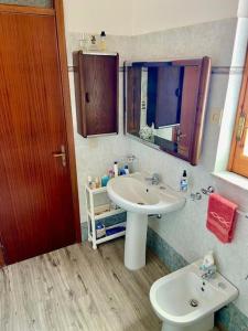 y baño con lavabo, espejo y aseo. en CASA CELSA, en Mongiove