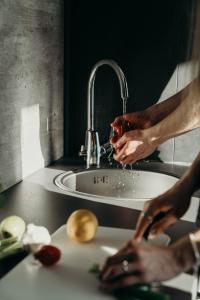 a person is drinking wine from a kitchen sink at Aurora Fjord Cabins in Lyngseidet