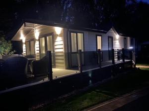 una piccola casa con luci sul portico di notte di Luxury Lodge Hoburne Devon Bay WG21 a Paignton