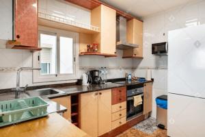 a kitchen with a sink and a refrigerator at Terrace Apartment in Sant Adria de Besos