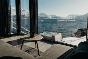 a living room with a view of the water at Aurora Fjord Cabins in Lyngseidet