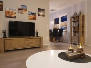 a living room with a flat screen tv on a entertainment center at Ferien am Idasee 85041 in Ostrhauderfehn