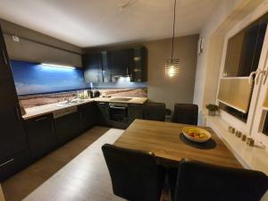 a kitchen with a wooden table and a dining room at Ferien am Idasee 85041 in Ostrhauderfehn