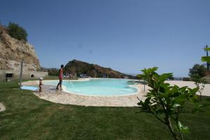 a man and a child standing next to a swimming pool at Resort Borgo San Rocco in Savoca 