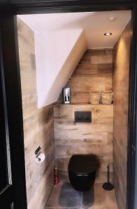 un bagno con un water nero e pareti in legno di Het Blij Hoen a Oudenbosch