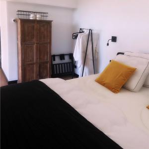 un letto bianco con cuscino giallo e cassettiera di Het Blij Hoen a Oudenbosch
