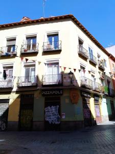 a white building with balconies on a street at Apartamento 2 dormitorios Barrio Lavapies in Madrid