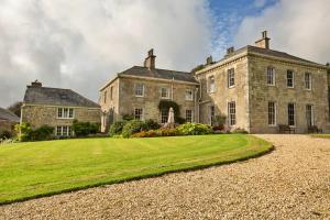 an old stone house with a large grass yard at Finest Retreats - Tresillian House in Newquay