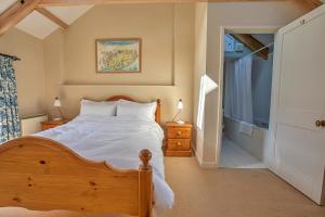 a bedroom with a wooden bed and a window at Finest Retreats - The Laundry Cottage in Newquay
