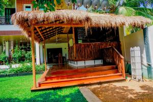Cabaña con techo de paja y escaleras en un patio en Even Beach Resort en Wayikkal
