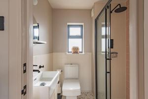 a bathroom with a toilet and a sink and a shower at Victory Cottage - Stunning home with sea views in Kingsdown +23 photos