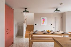 a dining room with a table and a staircase at Victory Cottage - Stunning home with sea views in Kingsdown