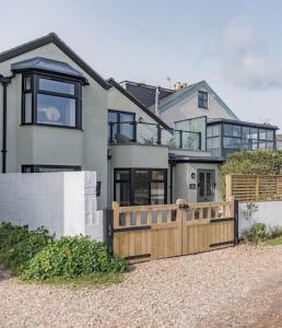 a house with a wooden fence in front of it at Victory Cottage - Stunning home with sea views in Kingsdown
