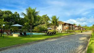 uma rua de calçada com uma casa e um resort em Apartamento na Vila La Torre em Porto Seguro