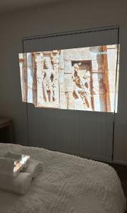duży ekran z obrazem na ścianie nad łóżkiem w obiekcie Trafalgar Place w Auckland