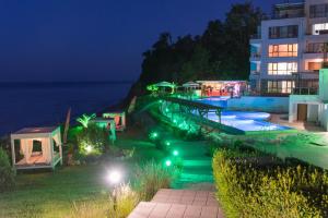 un complejo con piscina por la noche en White Cliffs, Byala, en Byala