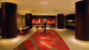 - un hall avec un tapis rouge, des chaises et une table dans l'établissement ANA Crowne Plaza Niigata, an IHG Hotel, à Niigata