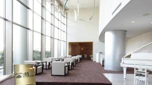 a large room with white chairs and windows at ANA Crowne Plaza Niigata, an IHG Hotel in Niigata