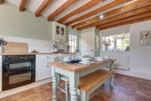 a kitchen with a table with dishes on it at Flint Cottage in Stiffkey