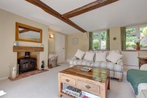 a living room with a couch and a fireplace at Flint Cottage in Stiffkey