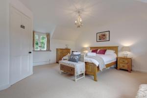 a bedroom with a bed and a chair and a window at Flint Cottage in Stiffkey
