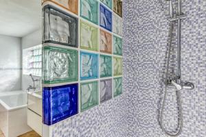 a bathroom with a shower with colorful glass tiles at Casa Nostra - Tramuntana in Colera +34 photos