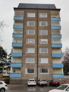 a tall building with cars parked in front of it at Renovated handy spacious 3 room apartment for tourists, workers and students in Rauma