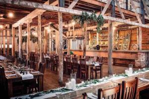 um restaurante com mesas e cadeiras de madeira e um bar em The Captain's Manor - Great location! em Corowa
